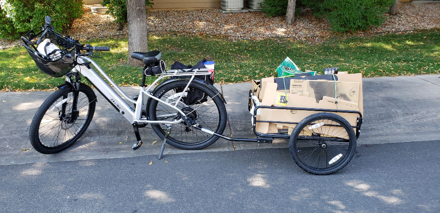A bike with a trailer attached full of cardboard