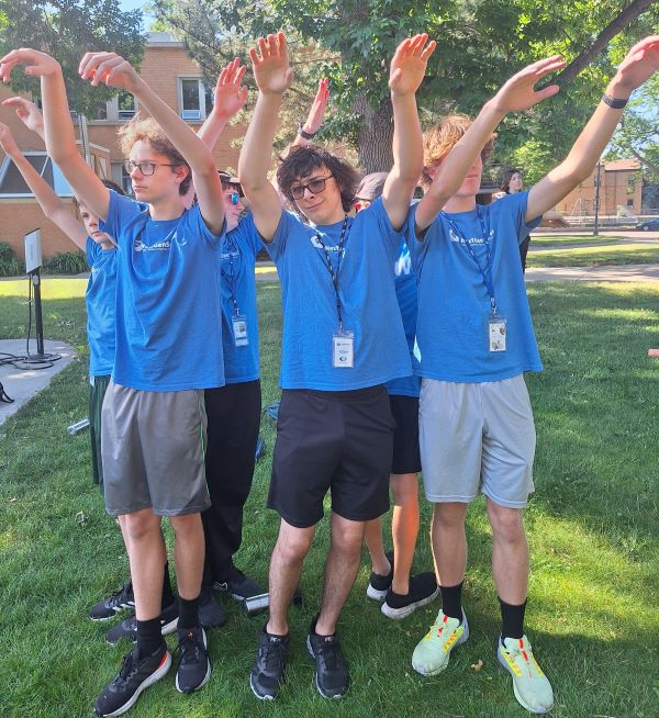 Teens with their hands in the air while playing a game!